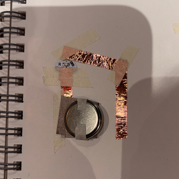 I created a small circuit that focused on using the LED sticker, using copper tape and conductive fabric. I taped the battery down onto the fabric, then used the other half of it as a switch.